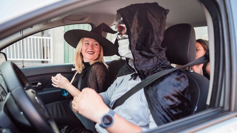 A family in a car, wearing Halloween costumes