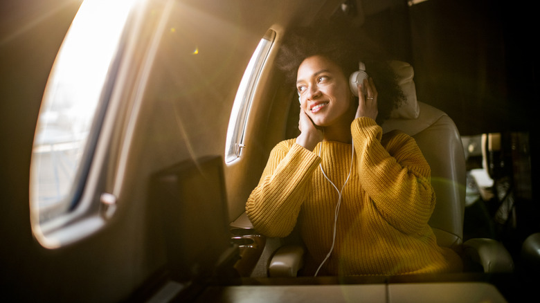 Woman on plane wearing noise cancelling headphones