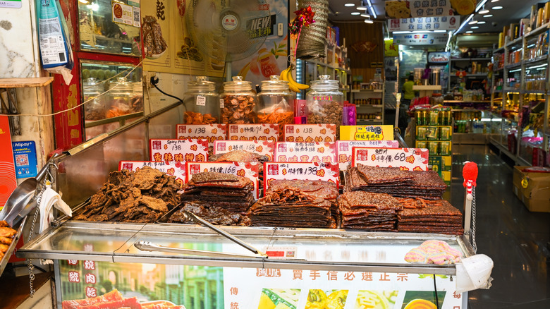 Traditional street food shop window display in Macau with dried meat jerky slices and price tags