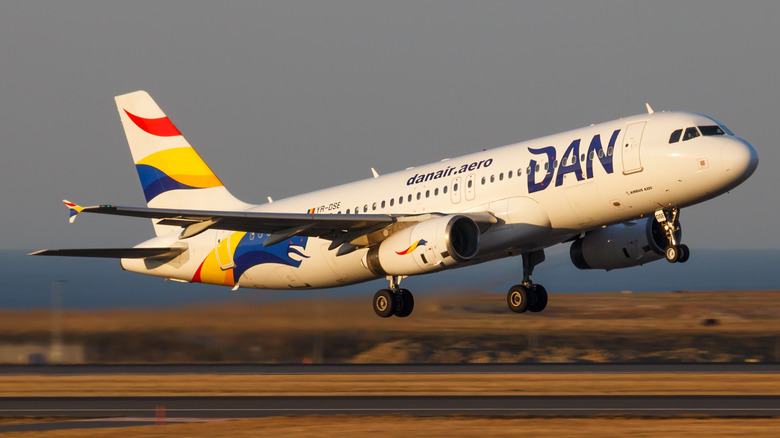 A Dan Air flight takes off from a European runway at sunset