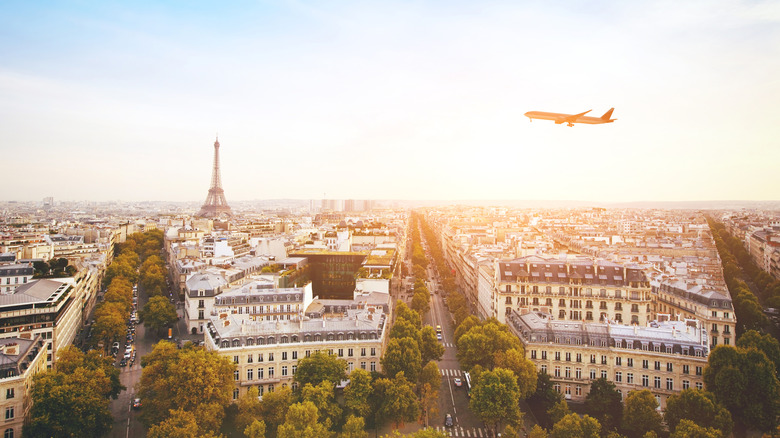Airplane flying over the Paris skyline with the Eiffel Tower