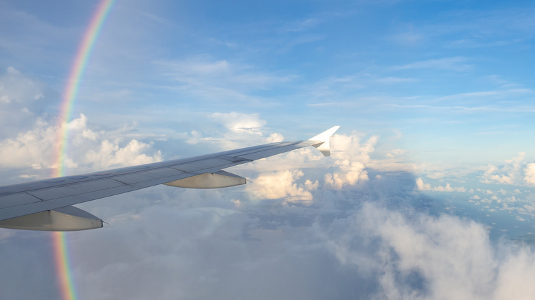 A rainbow arcs above the clouds