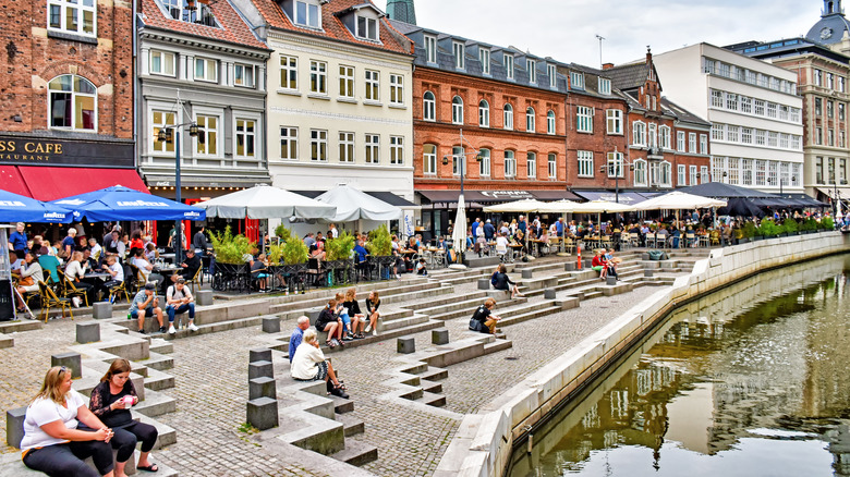 People enjoying the promenade along the river Aarhus.