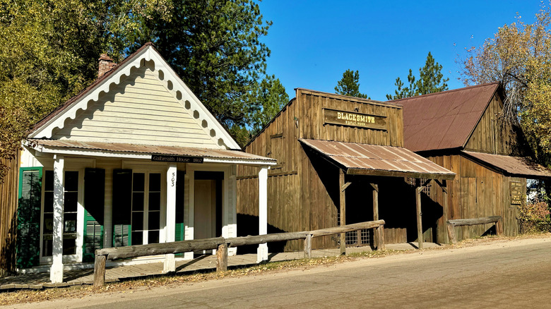 A white building a brown building against a backdrop of trees and blue sky in Idaho City