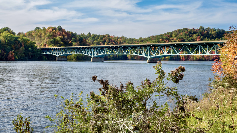 A bridge across Cheat Lake lined with colorful trees
