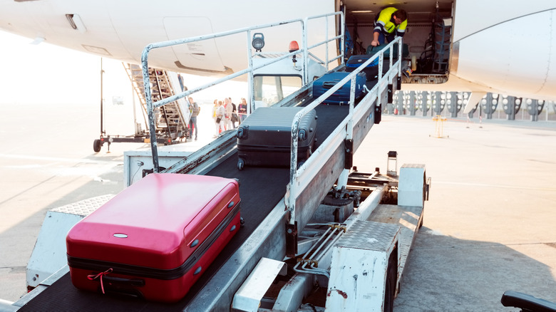 Checked luggage being loaded onto a plane