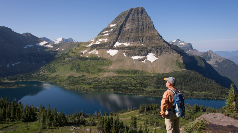 A hiker looking over a view of Hidden Lake and Bearhat Mountain in Glacier National Park, Montana