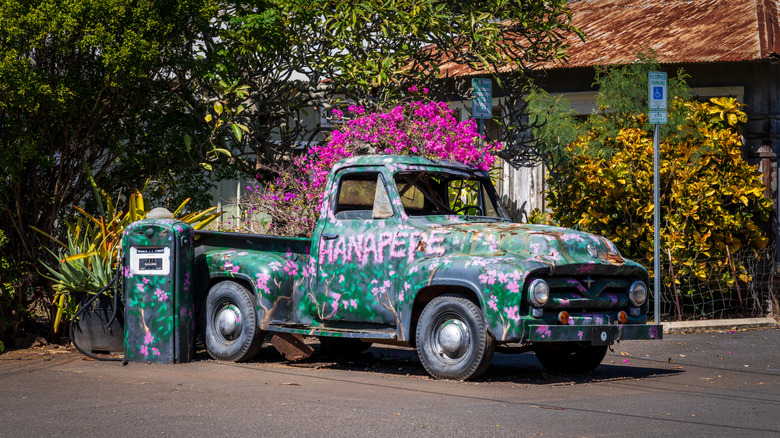 Hanapepe, Kauai - 2 February 2025: A vintage truck covered in flowers adds a pop of color to the charming streets of Hanapepe, Kauai.