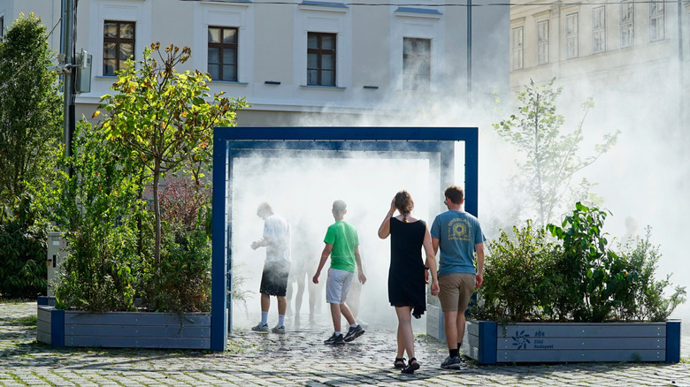 Tourists cool off in front of fountains and large fans in Paris