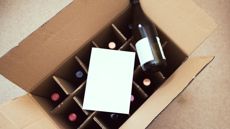 a cardboard box filled with red wine bottles
