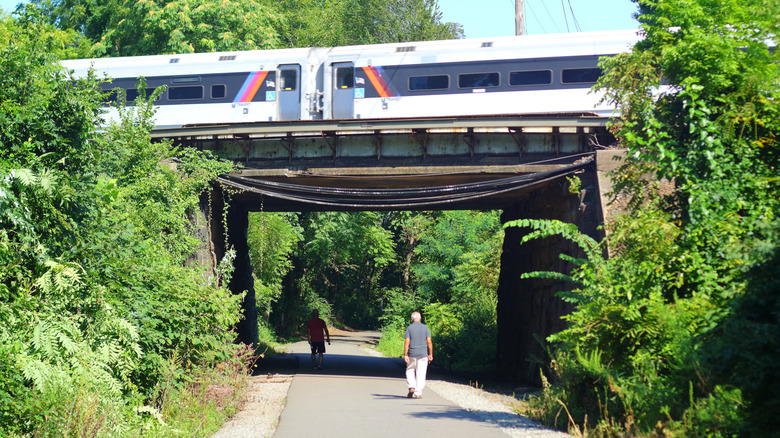 people walking under a train track in Middlesex Greenway