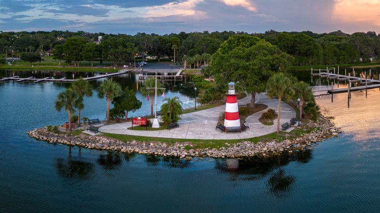 Landscape view of a red-and-white lighthouse in a park