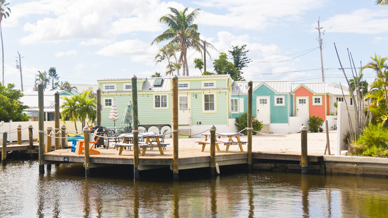 Colorful cottage and a pier with palm trees in the background