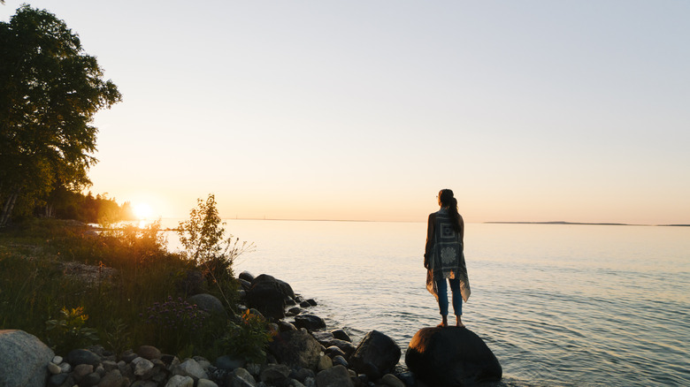 woman standing on a rock in front of Lake Huron