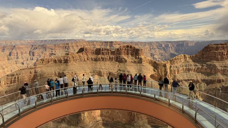 A group of tourists gaze out over the Grand Canyon from the West Skywalk