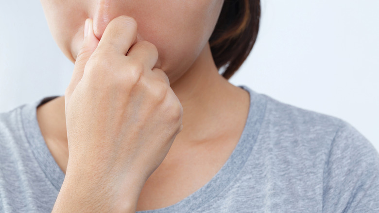 Woman holding her nose