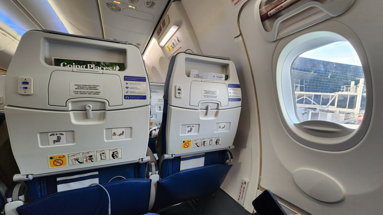 Interior view of a Malaysia Airlines Boeing 737-800 cabin showing the emergency exit row