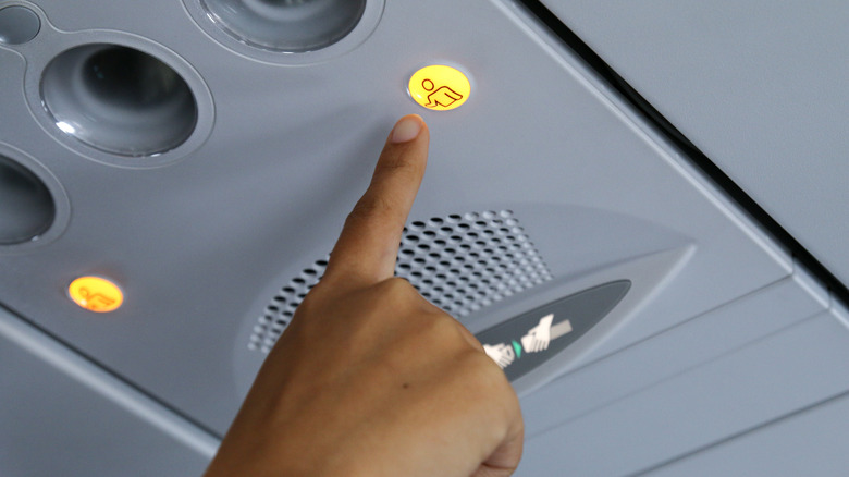 Hand pressing airplane call button