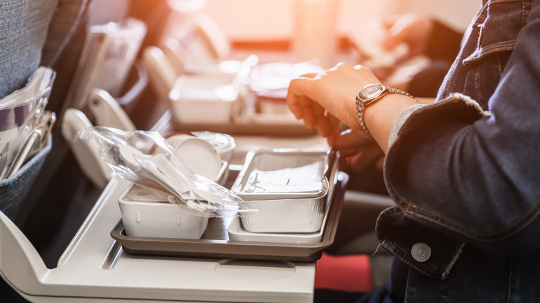 Woman unwrapping an airplane meal