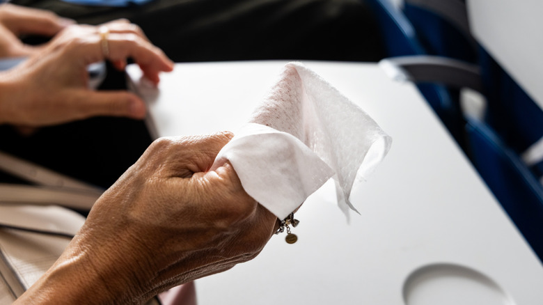 Closeup of hands holding a sanitizer wipe during flight