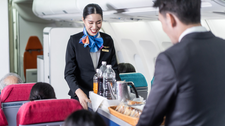 Two flight attendants serving drinks
