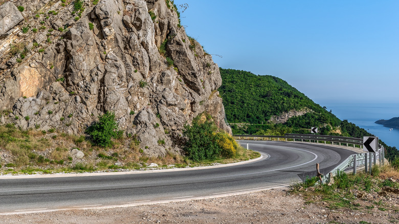 Winding mountain road heading down to the blue sea in Montenegro