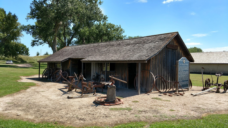 Historic building with antique farming equipment at Fort Hartsuff in Nebraska