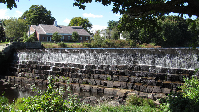 A manmade waterfall next to a small building.