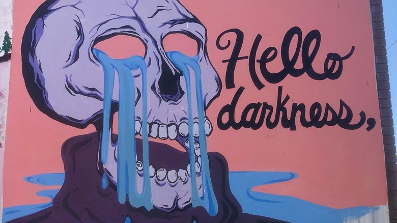 A mural of a skeleton crying that reads "Hello darkness"