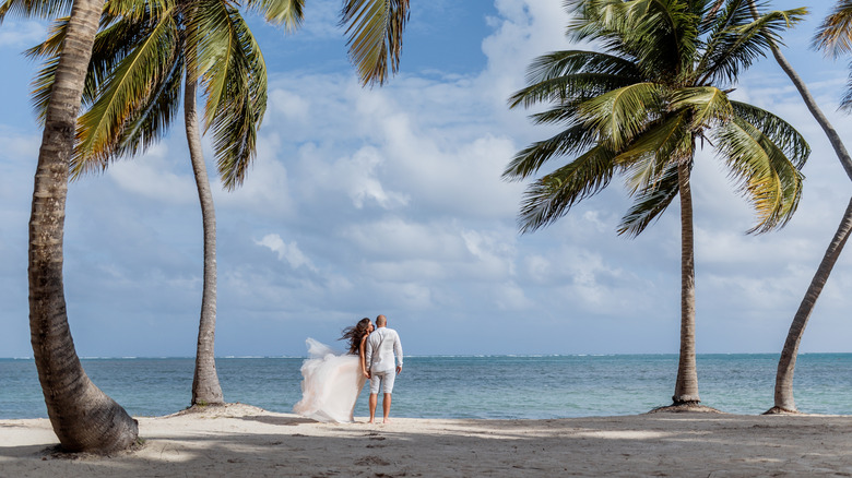 A bride and groom couple in wedding attire on the beach in Dominican Republic