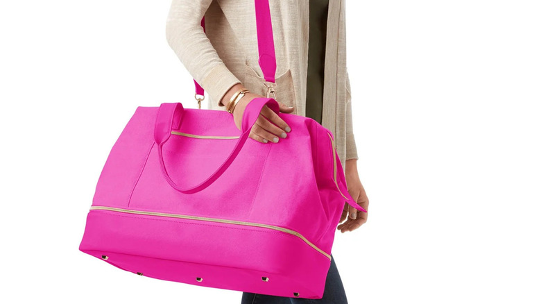 Woman carrying a weekender bag in hot pink