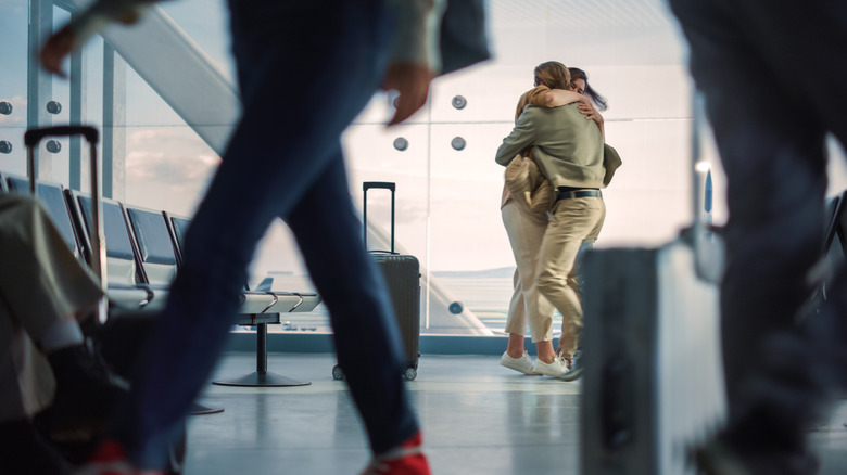 People hugging at an airport