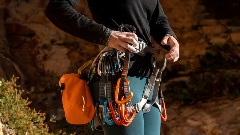 Climber with gear at bottom of cliff