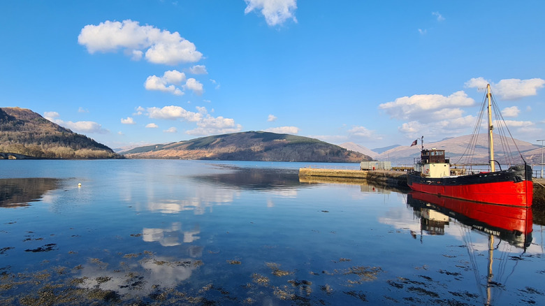 A boat moored in Loch Fyne with rolling hills behind it.