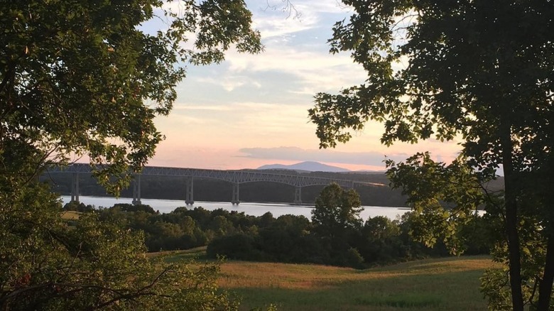 Hudson River at sunset with field and trees in foreground