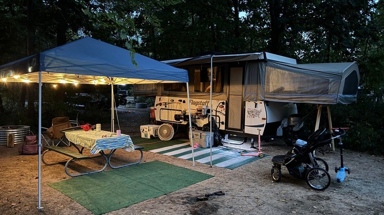 A campsite set-up with a trailer, picnic table, fire ring and twinkling lights at Van Buren State Park, Michigan