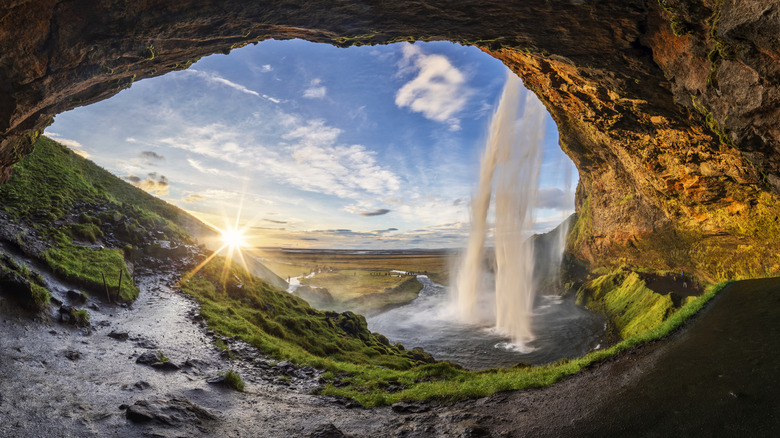 A dramatic sunset visible from inside the cave behind Seljalandsfoss in Iceland