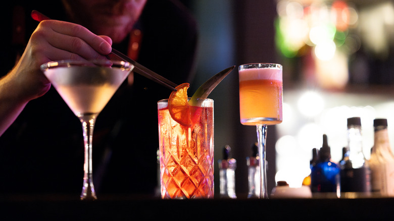 A man putting a garnish on beautiful cocktails