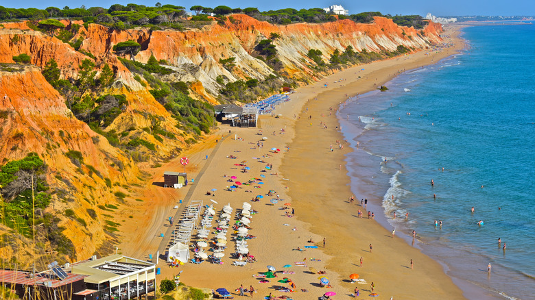 Long beach with orange cliffs behind