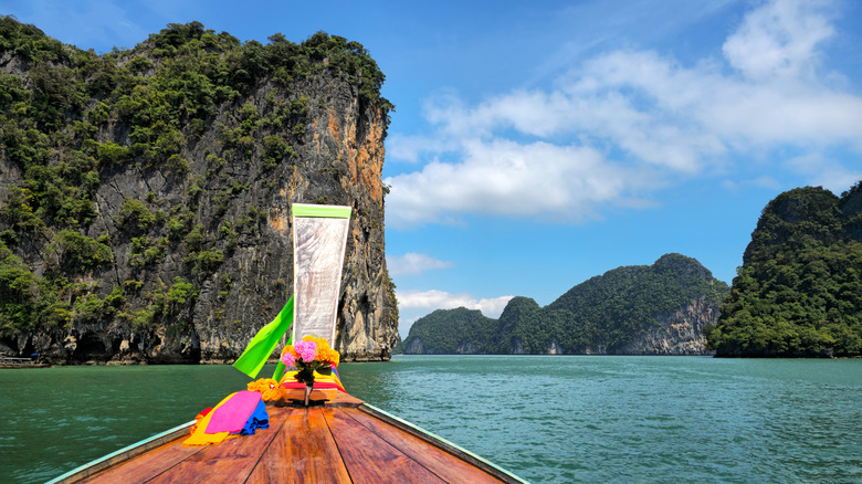 A traditional Thai longtail boat traveling through Phang Nga Bay