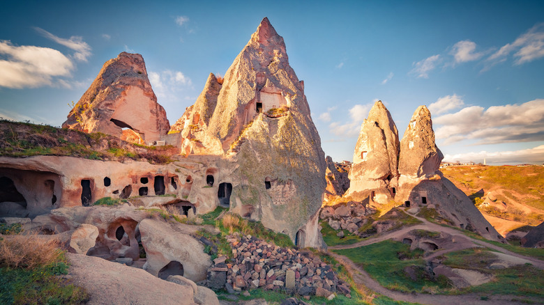 Basalt rock towers with ancient homes carved into them at sunset