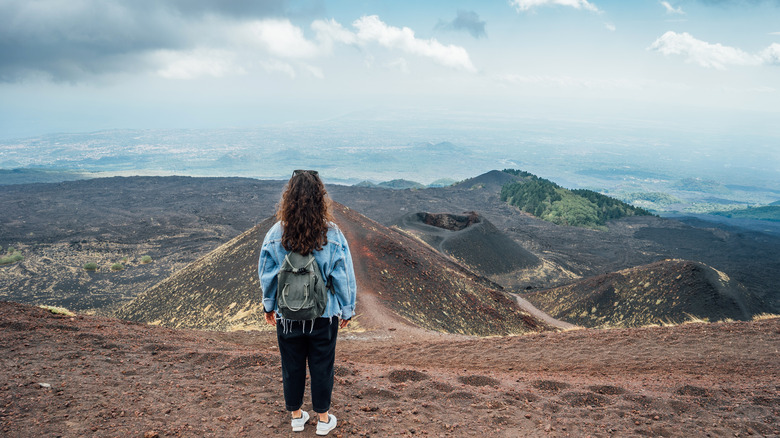 Woman standing at summit of volcano