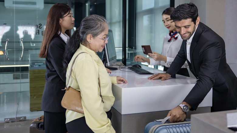 passengers check a bag at their departure gate
