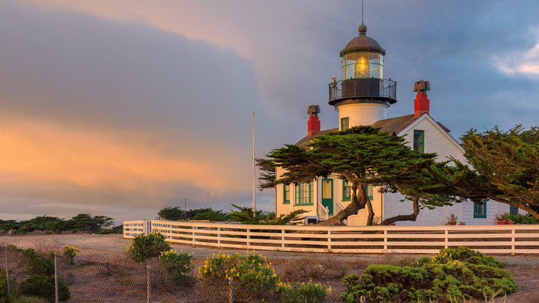 Point Pinos Lighthouse's beacon lights up at sunset in Pacific Grove, California.