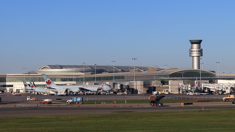 Outside view of airplanes and air traffic control tower at Toronto's Pearson International Airport (YYZ)
