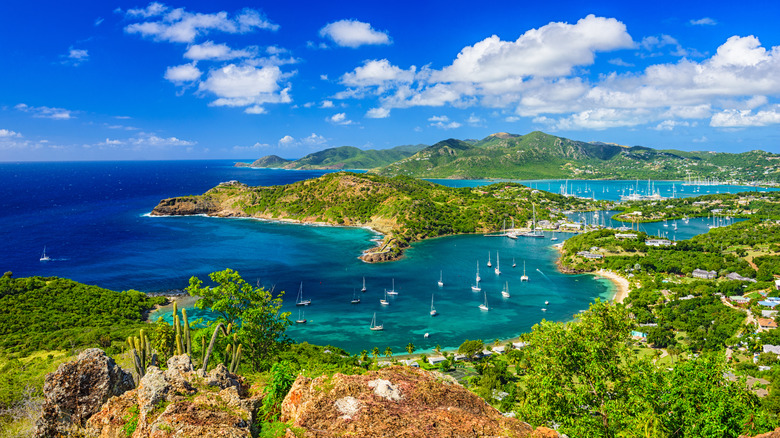 The lush green island of Antigua with turquoise bays dotted with boats