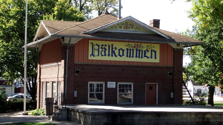 A brick building with a Swedish welcome sign and design in Stromsburg's town center.
