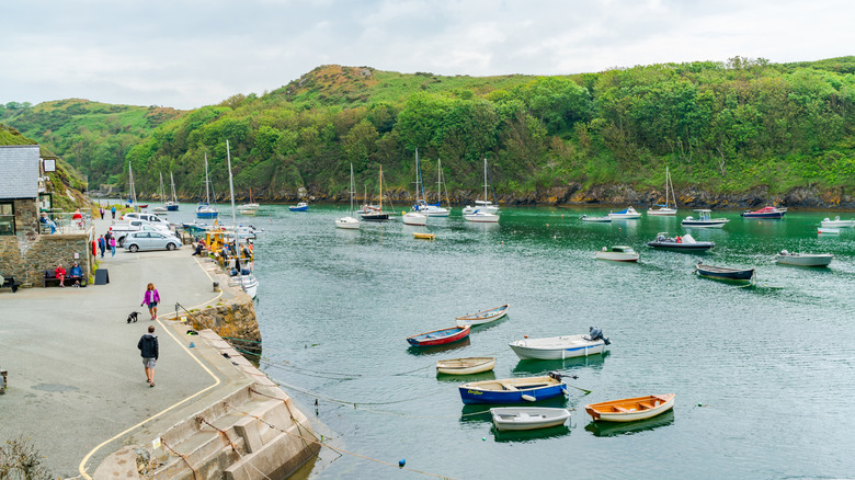 People walk along the harbor in Solva, Wales