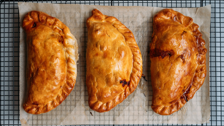 Three cornish pastries on baking sheet