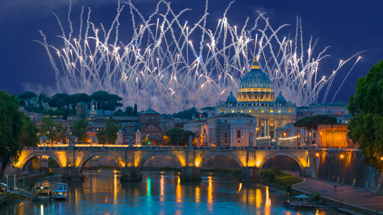 Evening view of St. Peter's Basilica and river with fireworks